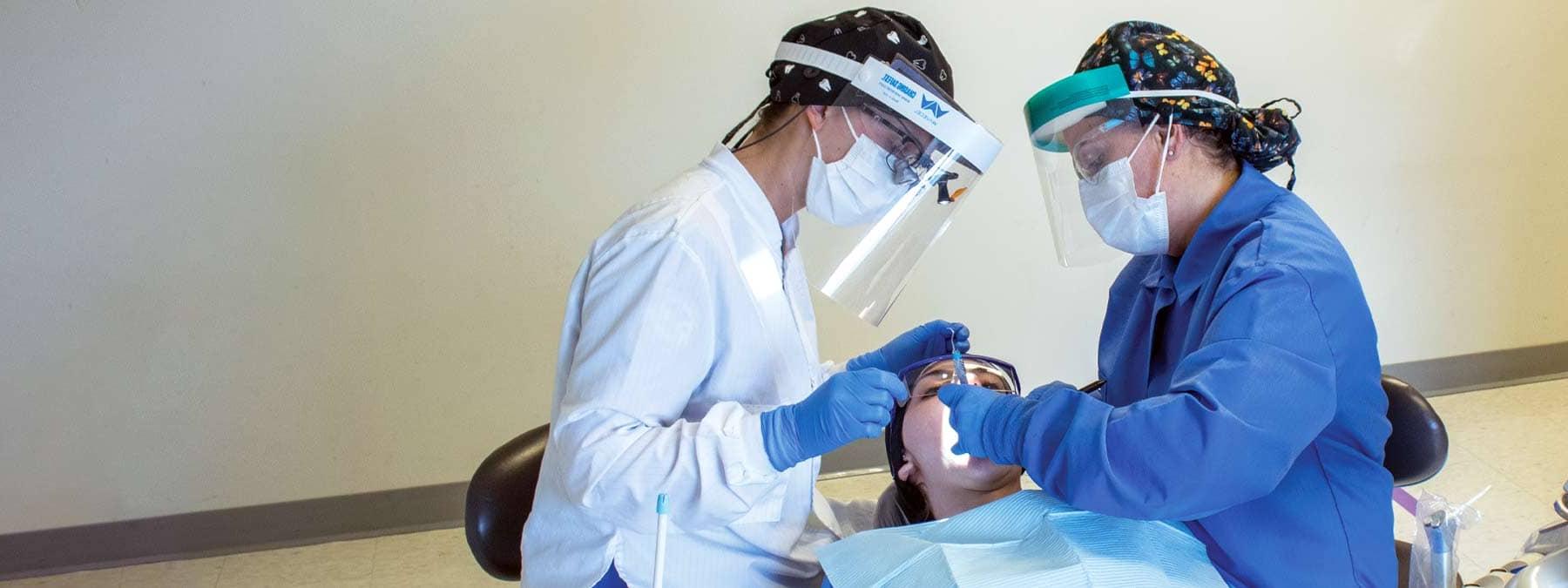 两个牙科学生正在治疗一个病人